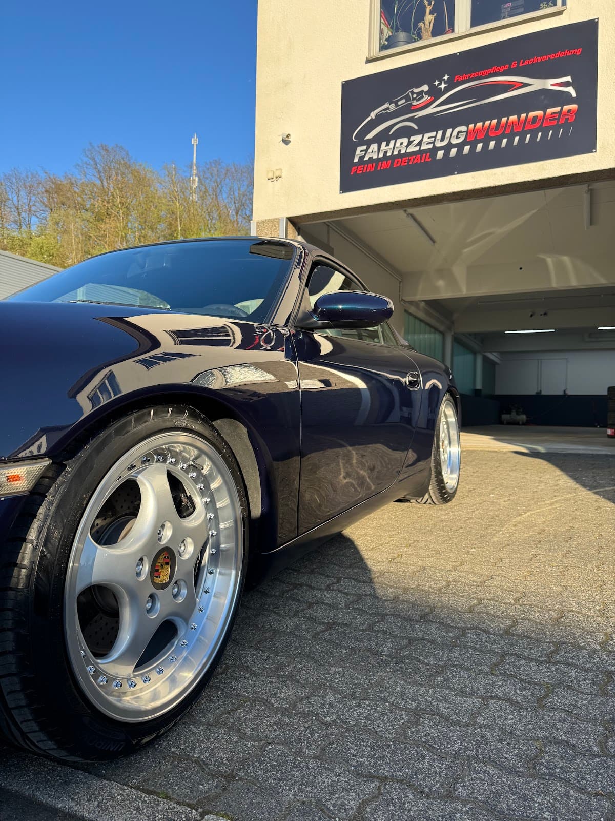 Porsche vor dem Firmenschild